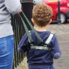 Toddler walking on pavement in camouflage baby reins 