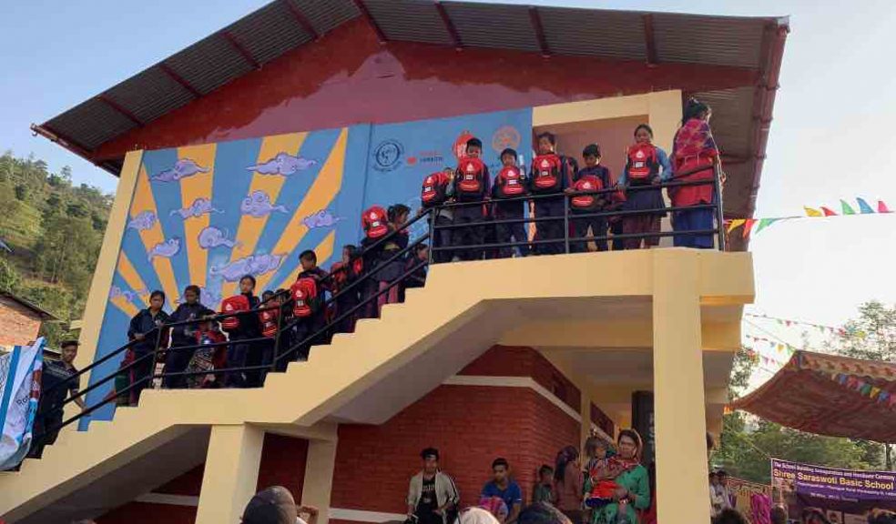 Children at the new school with their bags