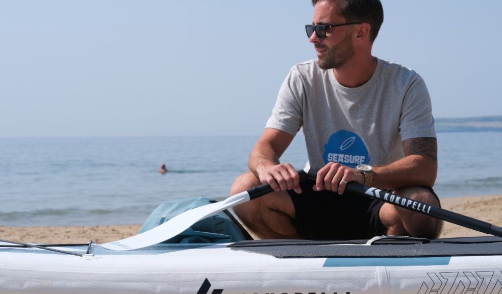 Picture shows paddleboatrder with his board and oars