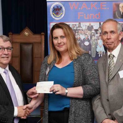 Pam Knight from Families for Children receiving the cheque from Ian Kingsbury accompanied by Mike Billington of Ashburton Lodge.