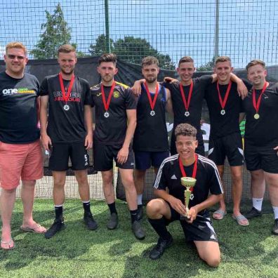 Marcel's Allstars, men's winners of the Exeter City FC One Game One Community Group community diversity football tournament, with Simon Kitchen from ECFC OGOC group, left. Photo: Alan Quick