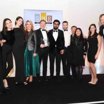 Layla Anna-Lee (MC), VHR (Business of the Year More Than 50 Employees and Overall Winner) and Brendan Brien (Clydesdale Bank) onstage at the SME National Business Awards 2019 at Wembley Stadium, London]